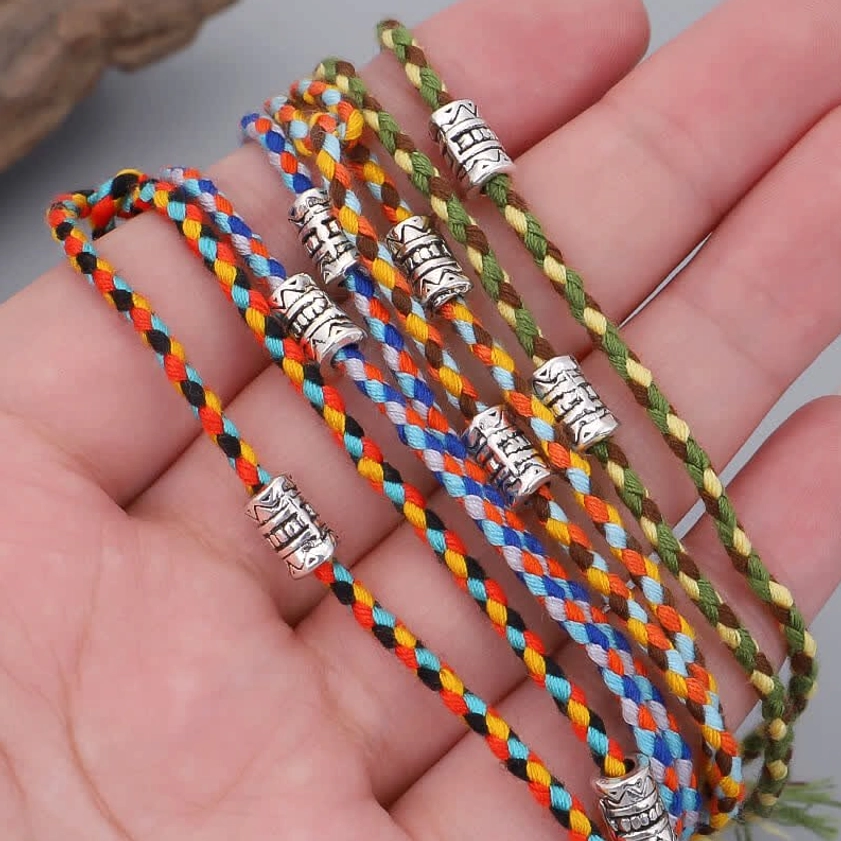 Buddha head string bracelets displayed on human palm, showing actual size and wearable fit