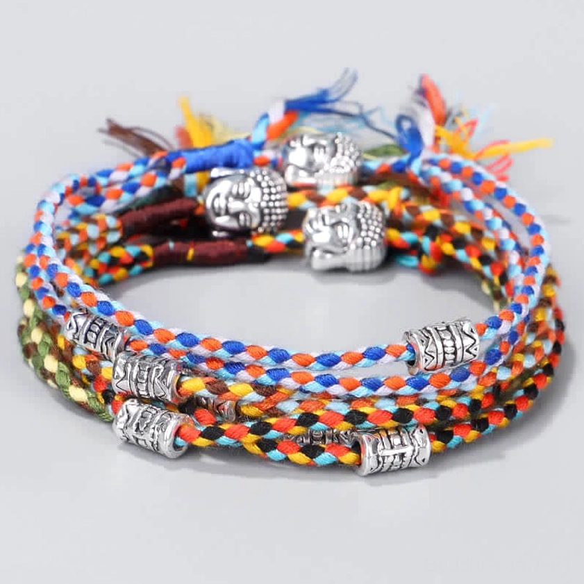 Multiple Buddha head string bracelets in various colors stacked together, overhead view showing different color options