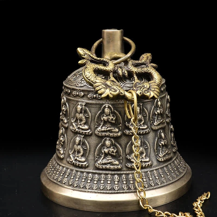 Top detail of copper wind chime bell showing dual dragon ornament finial and brass chain hanging hardware