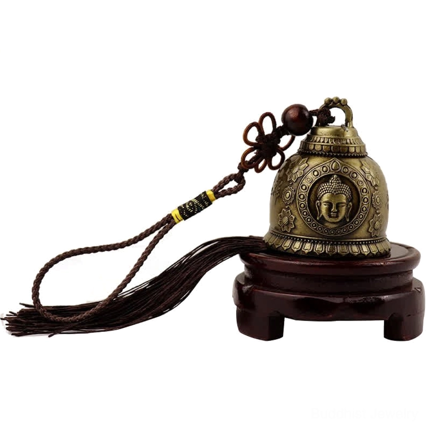 Buddha face wind chime decoration displayed on wooden stand showing vintage bronze finish and tassel