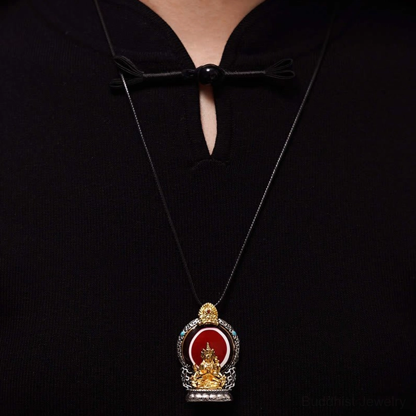 Mini Tibetan Buddhist Avalokitesvara pendant necklace worn close-up on black traditional clothing with thin black cord