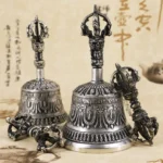 Authentic handmade Buddhist meditation bell and vajra dorje copper set overhead view with intricate religious carvings and traditional calligraphy