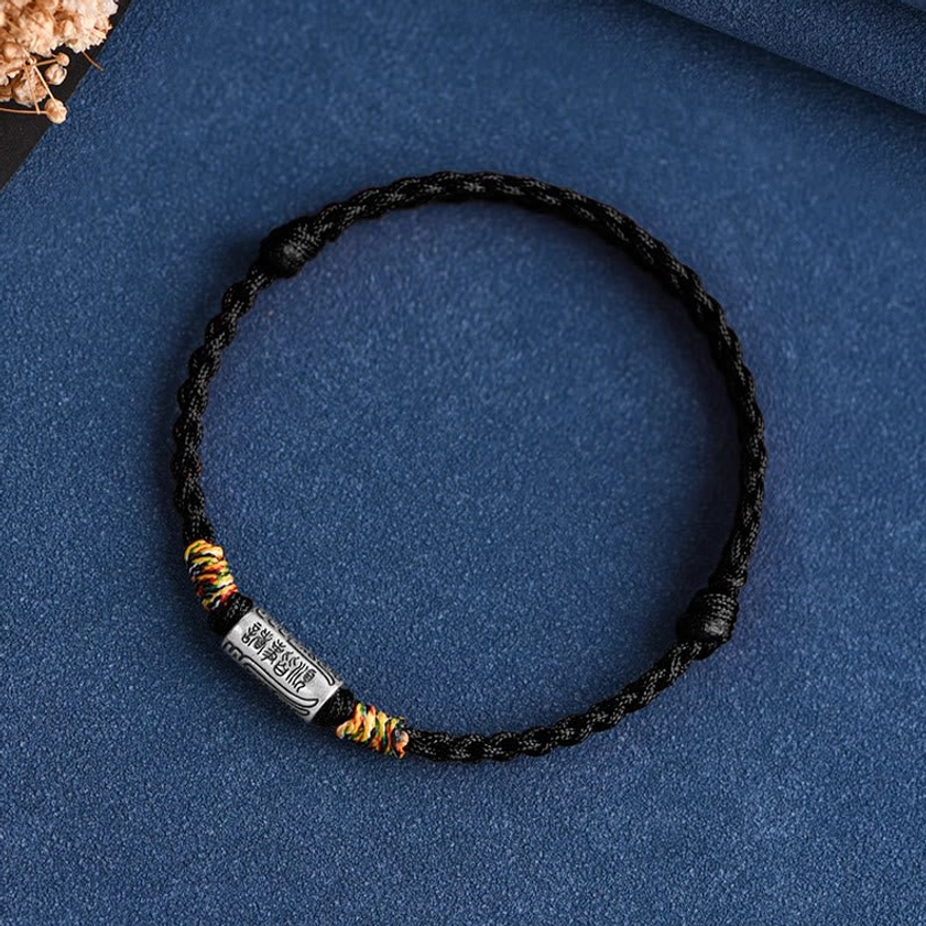 Buddhist protection bracelet with pure black braided rope and sterling silver protection charm, meditative energy symbolism
