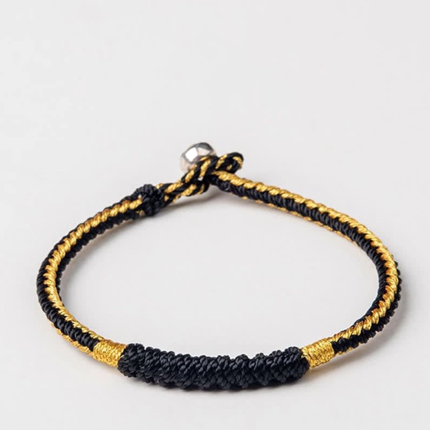 Black and gold handmade braided Buddhist string bracelet with thick woven middle section and durable metal clasp