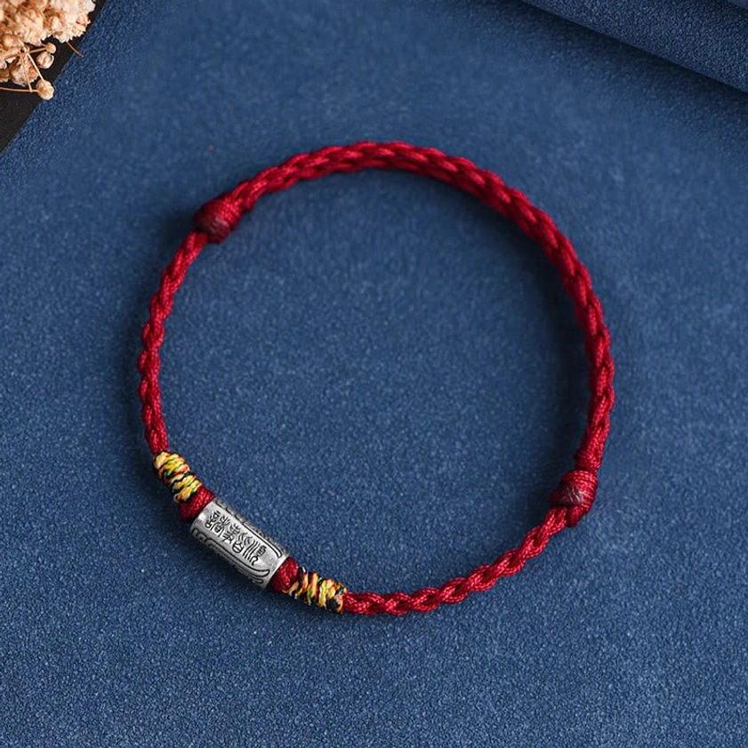 Buddhist blessing bracelet featuring dark red rope with engraved sterling silver tube charm, spiritual character design detail