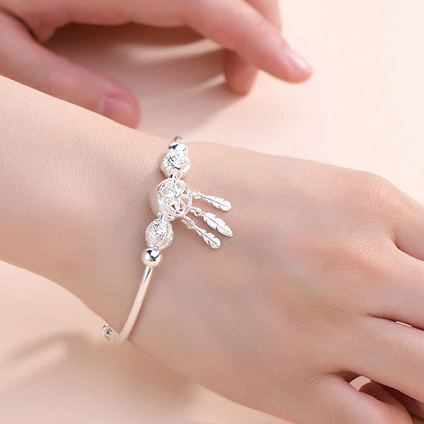 Front wear view of handcrafted silver dream catcher buddhist blessing bracelet with dainty hollow decorative beads on female hand
