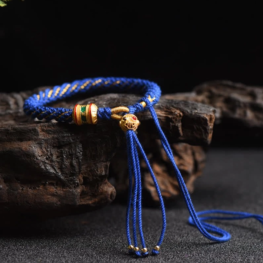 Blue Buddhist prayer wheel lucky charm string bracelet with adjustable braided cord and metal accents