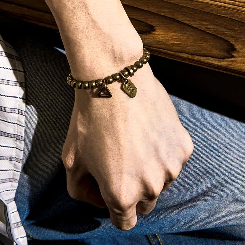 Back view of handcrafted copper bracelet with engraved Good Luck tag and metal bead connectors