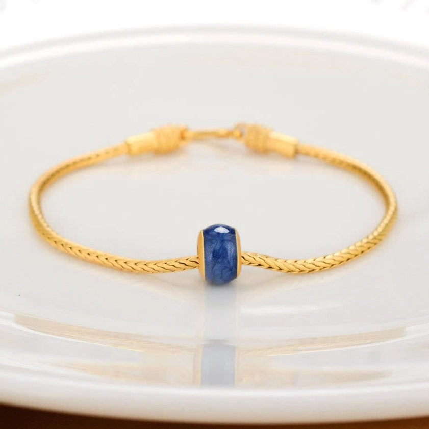 Buddhist bracelet with blue cylindrical enamel bead charm on twisted snake chain