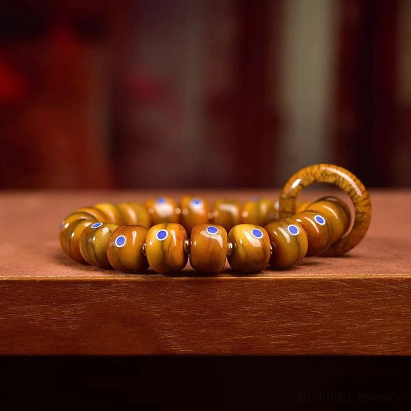 Side profile view of authentic Buddhist bracelet showing aged bone beads and blue stone inlays