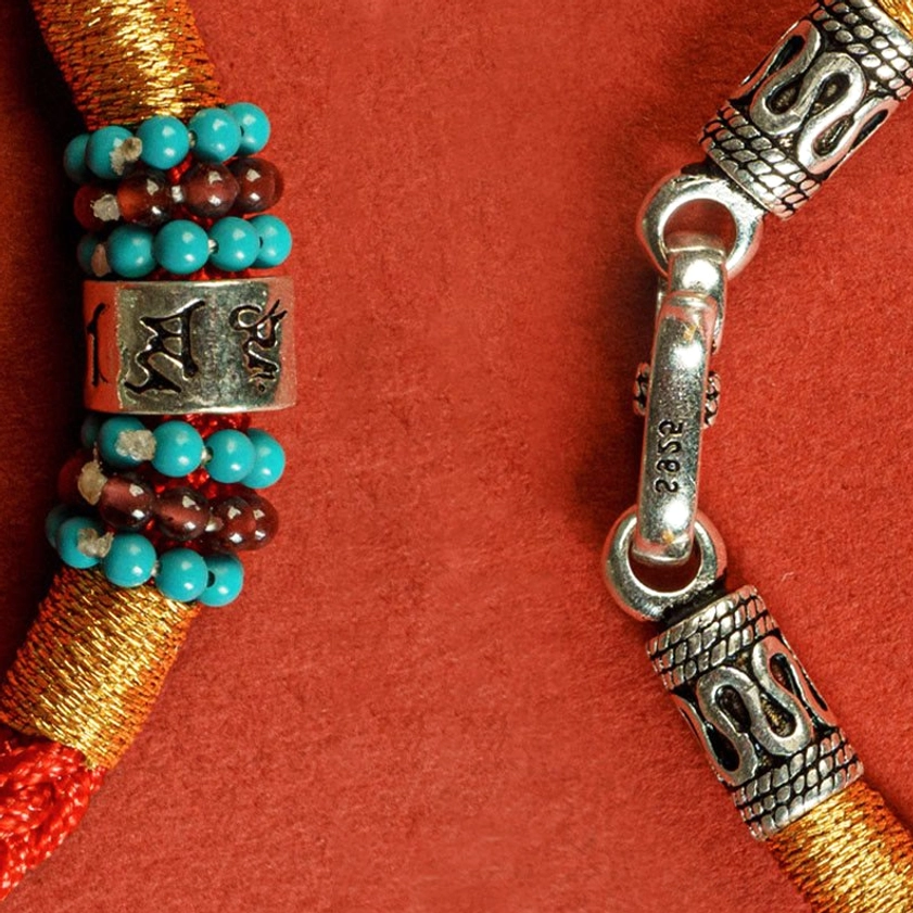 Buddhist string bracelet collection showcasing different cord colors and sterling silver designs