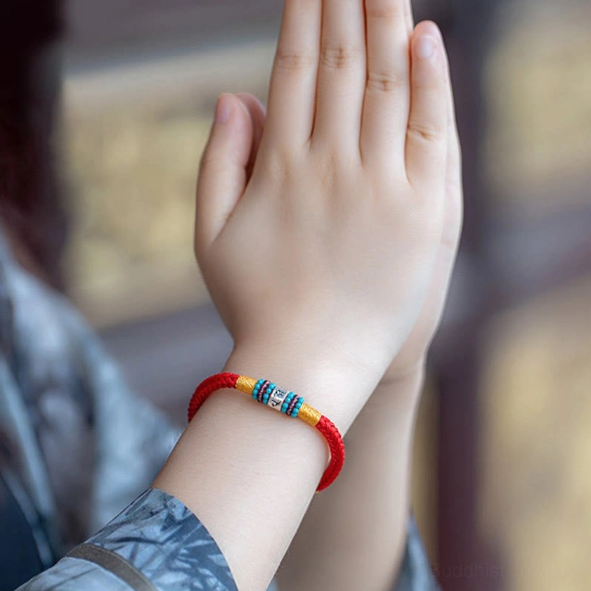 Multiple color options of Buddhist string bracelets showing red black and brown cord varieties
