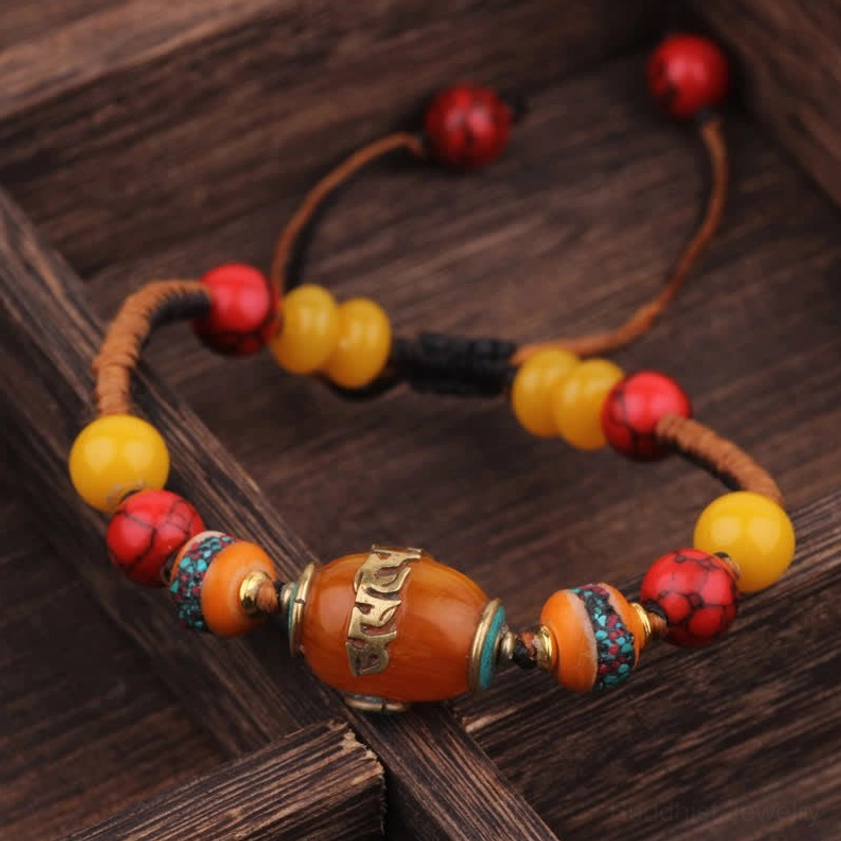 Buddhist braided bracelet with decorative metal inlays on central bead, artisan handcrafted spiritual jewelry