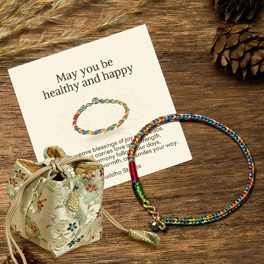 Multicolor Buddhist blessing bracelet with personalized greeting card and embroidered fabric gift pouch on wooden table