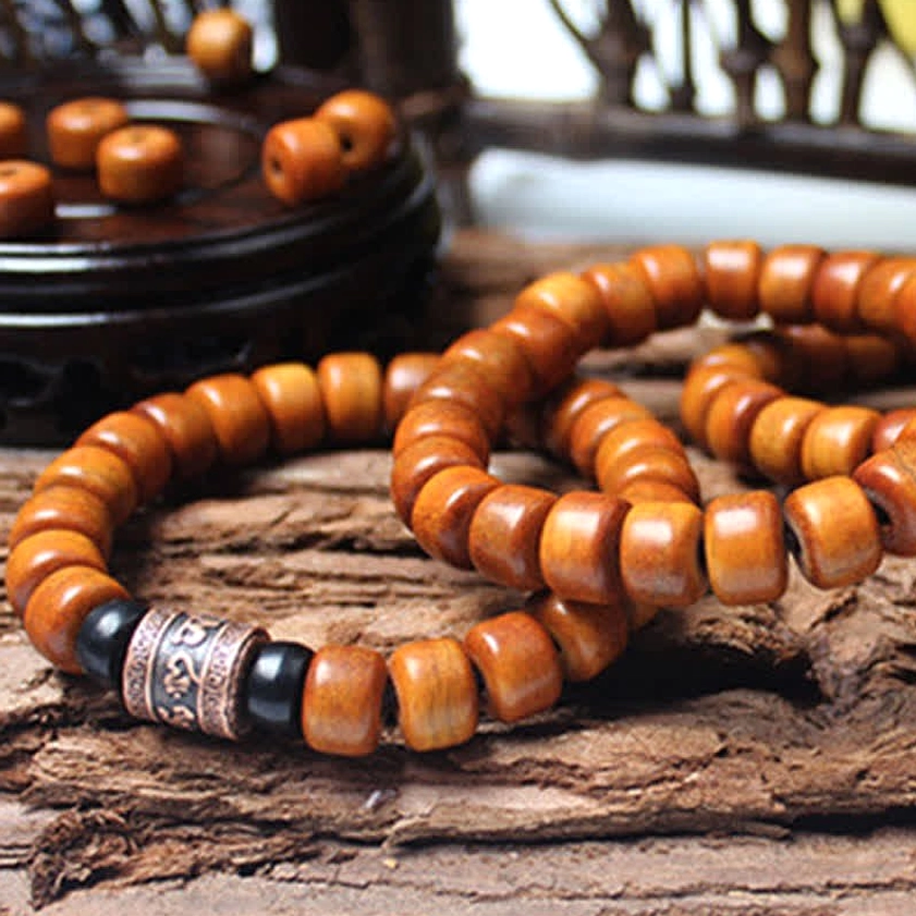 Double wrap Buddhist meditation bracelet with brown barrel beads and dark blue lazurite accent stone
