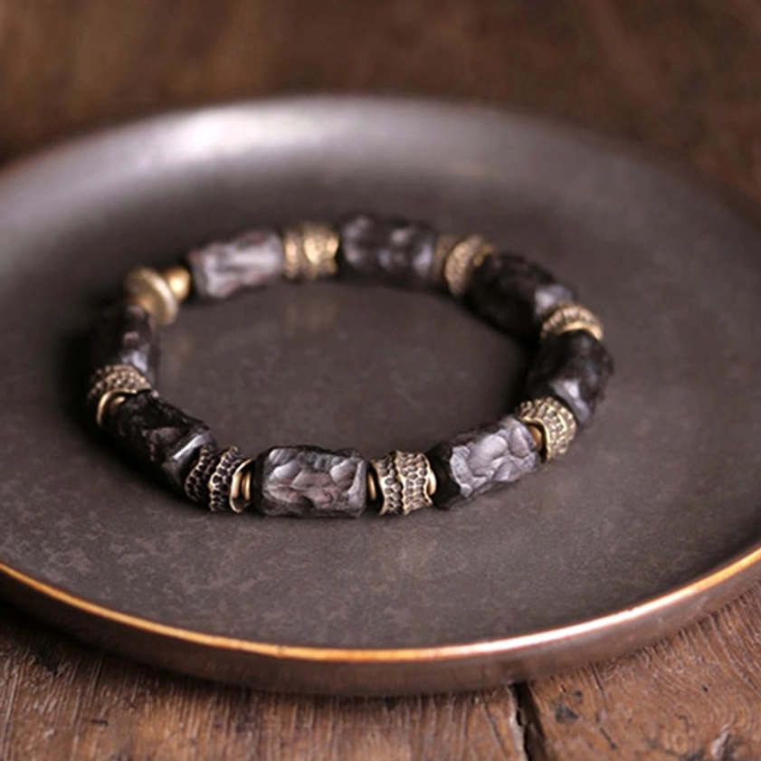 Buddhist ebony wood copper bracelet flat lay design detail on wooden table