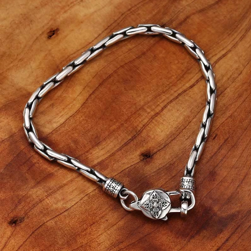 Buddhist spiritual bracelet with floral engraved clasp and polished vintage silver tone linked chain