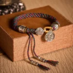 Dark Colorful Braided Buddhist Bracelet with Fu Character and Om Mani Padme Hum Symbols on Wooden Gift Box