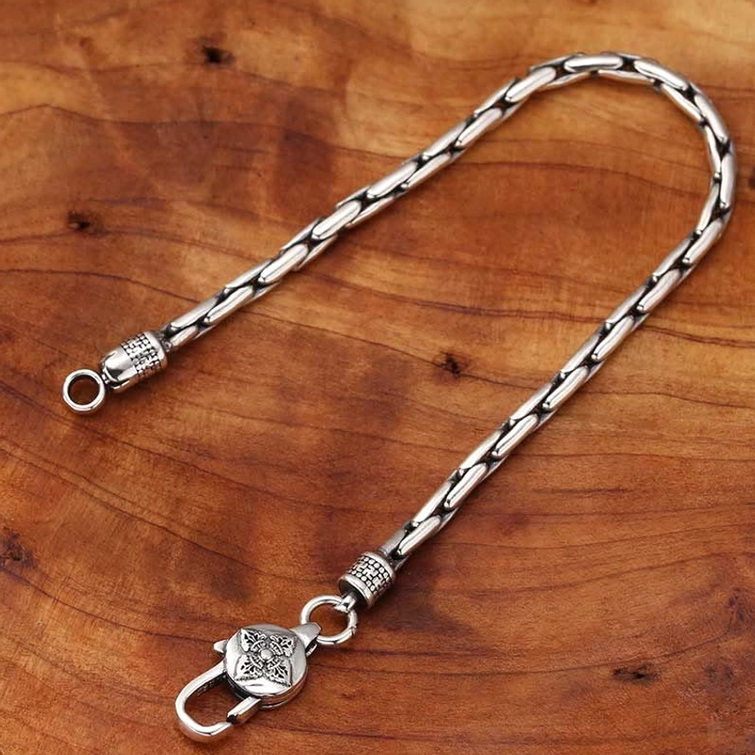 Unfolded Buddhist silver bracelet displaying full linked curb chain and carved clasp details in vintage finish