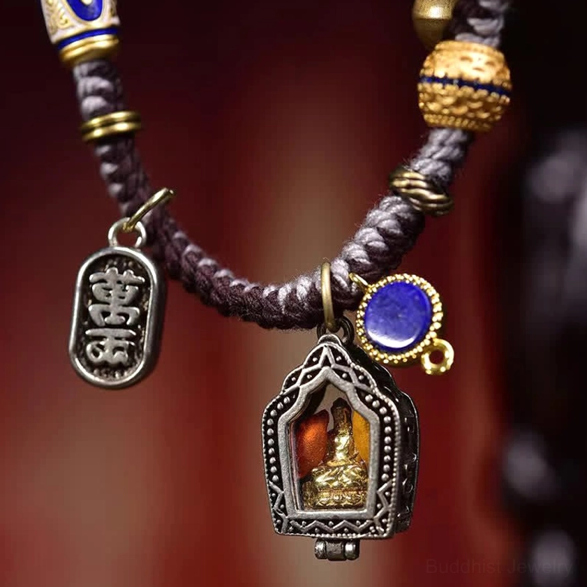 Macro close-up of Buddhist bracelet featuring engraved Chinese charm, shrine pendant, and blue stone accent detail