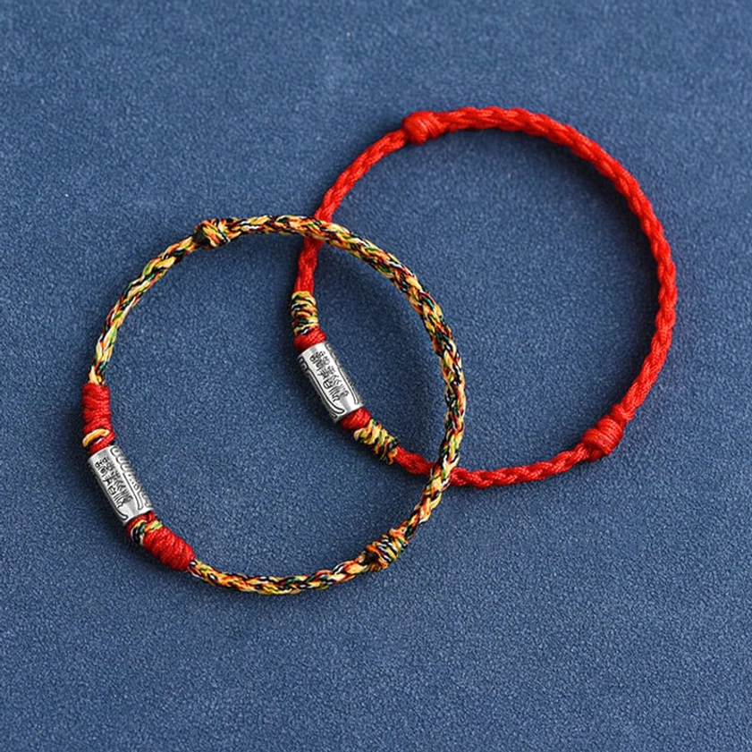 Handcrafted Buddhist protection bracelet showing rope construction method and silver charm integration, artisan detail closeup