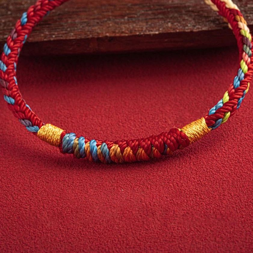 Close-up of multicolored woven threads and twisted rope texture of Buddhist protection bracelet