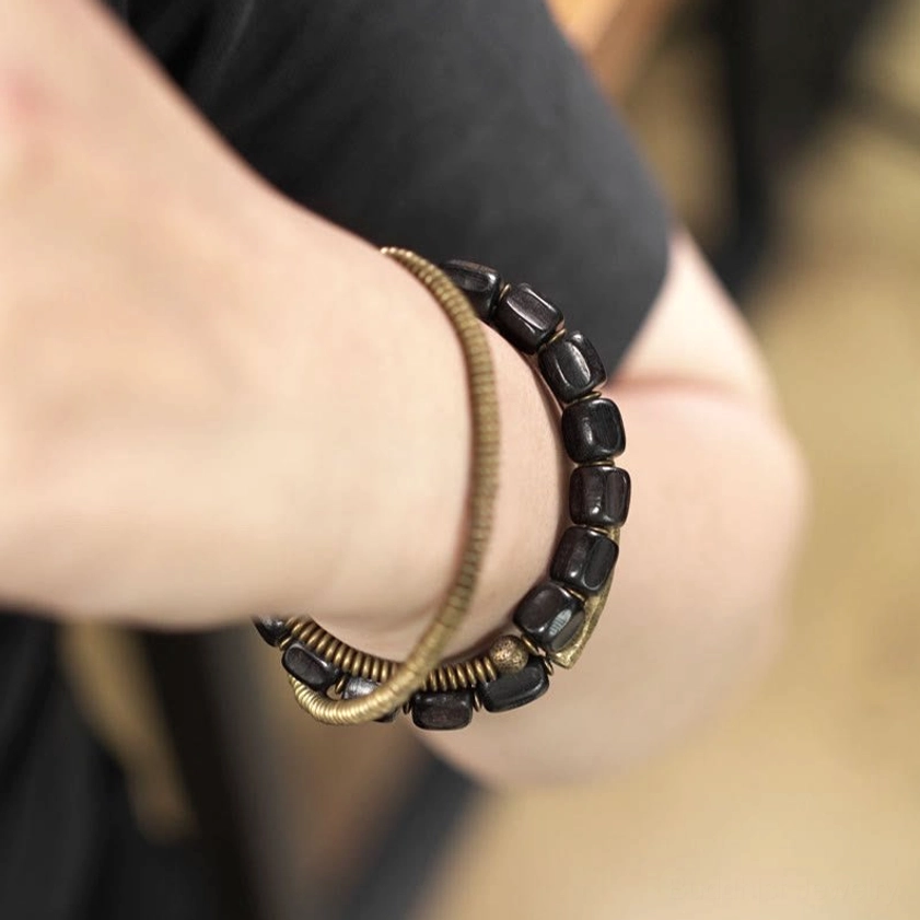 Side angle view of layered Buddhist bracelet showing mixed ebony wood and copper beads
