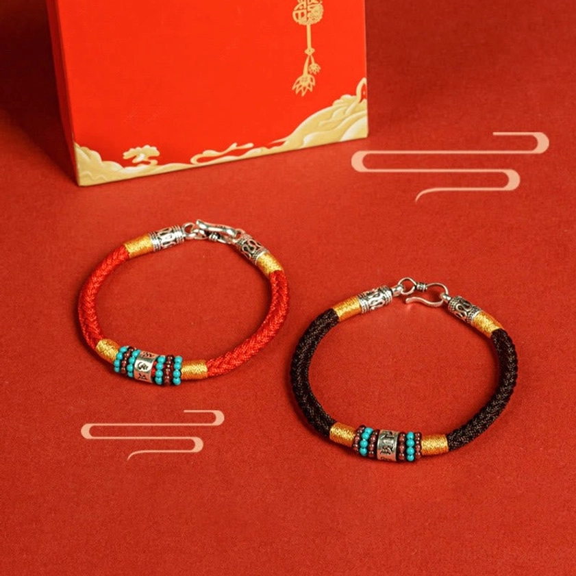 Buddhist string bracelet close-up showing detailed silver engraving and mantra character