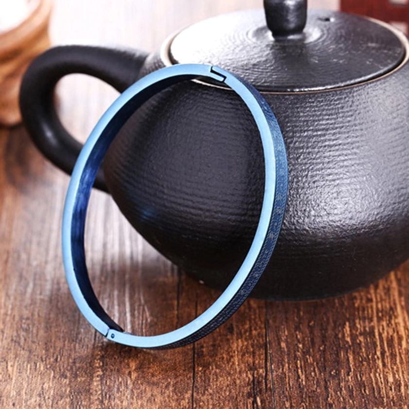 Full circular open cuff titanium steel blessing bracelet in matte blue finish, displayed at oblique front angle