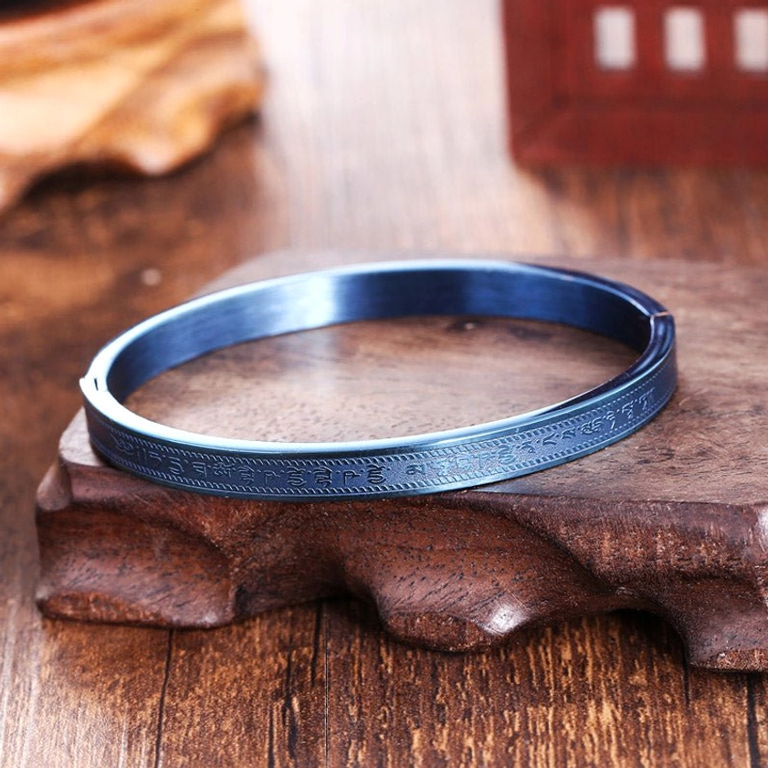 Clear scripture engravings and open cuff structure of titanium steel Buddhist blessing bracelet, top-down flat lay
