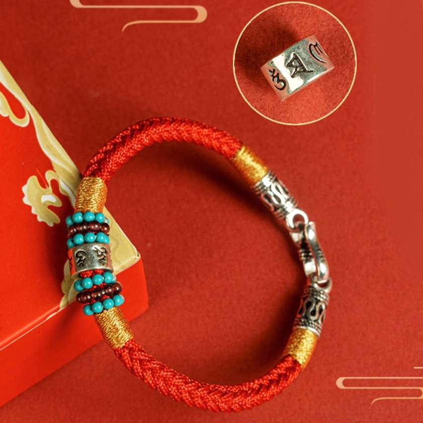 Buddhist string bracelet with turquoise and sterling silver accents on woven cord