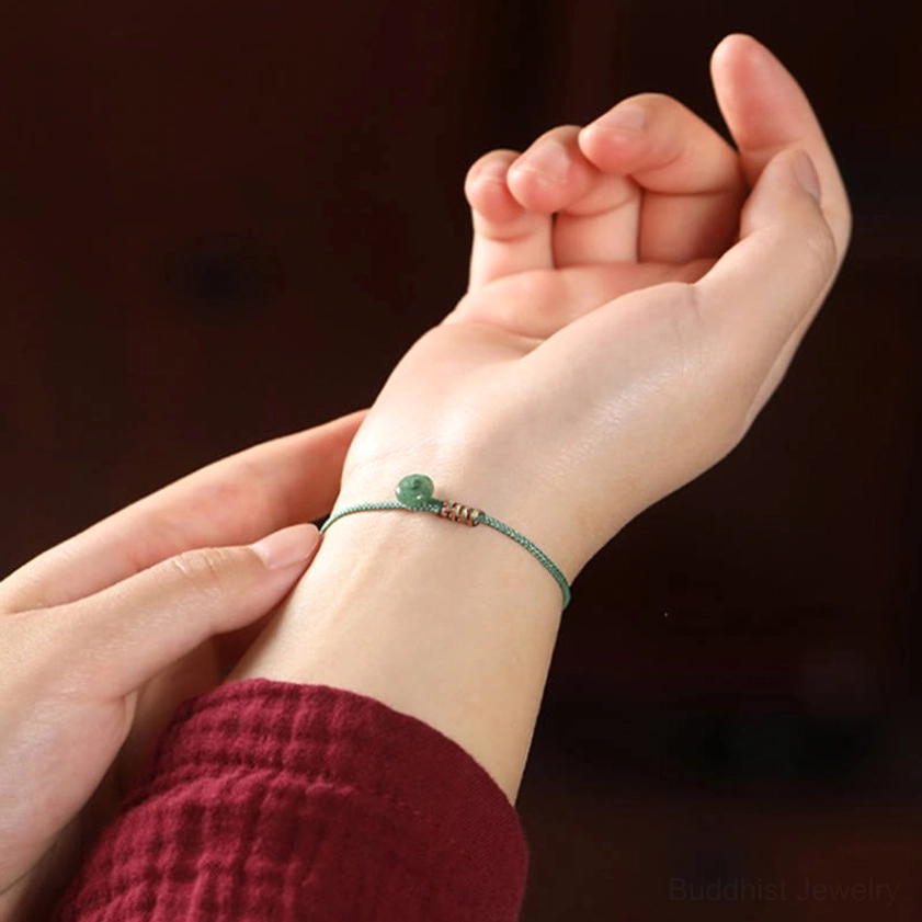 Green aventurine Buddhist string bracelet worn on wrist, close-up hand view showing fit and natural bead texture