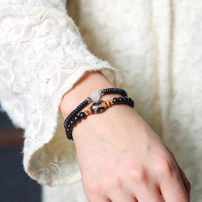 Worn double wrap beaded Buddhist bracelet on wrist showing how ebony wood and dzi bead bracelet looks in daily wear