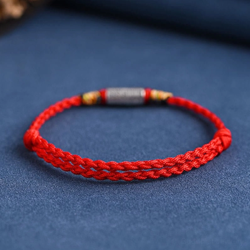 Neat woven red rope Buddhist bracelet with 925 sterling silver hardware, front view showing tight weave texture and charm attachment