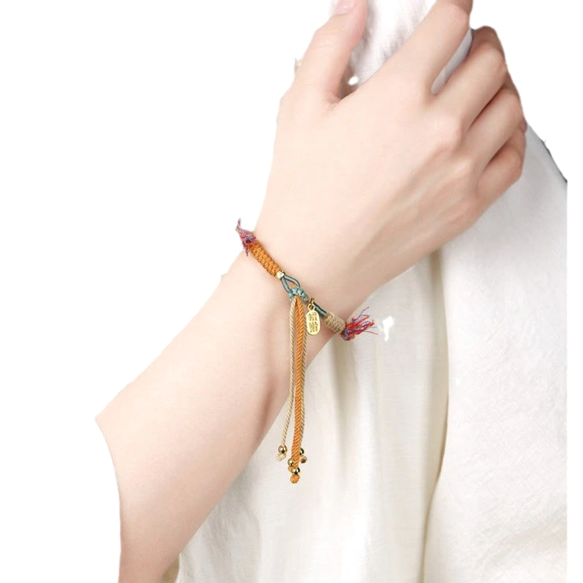 Buddhist luck bracelet worn on wrist showing natural fit, multicolor braided rope, and hanging tassel detail