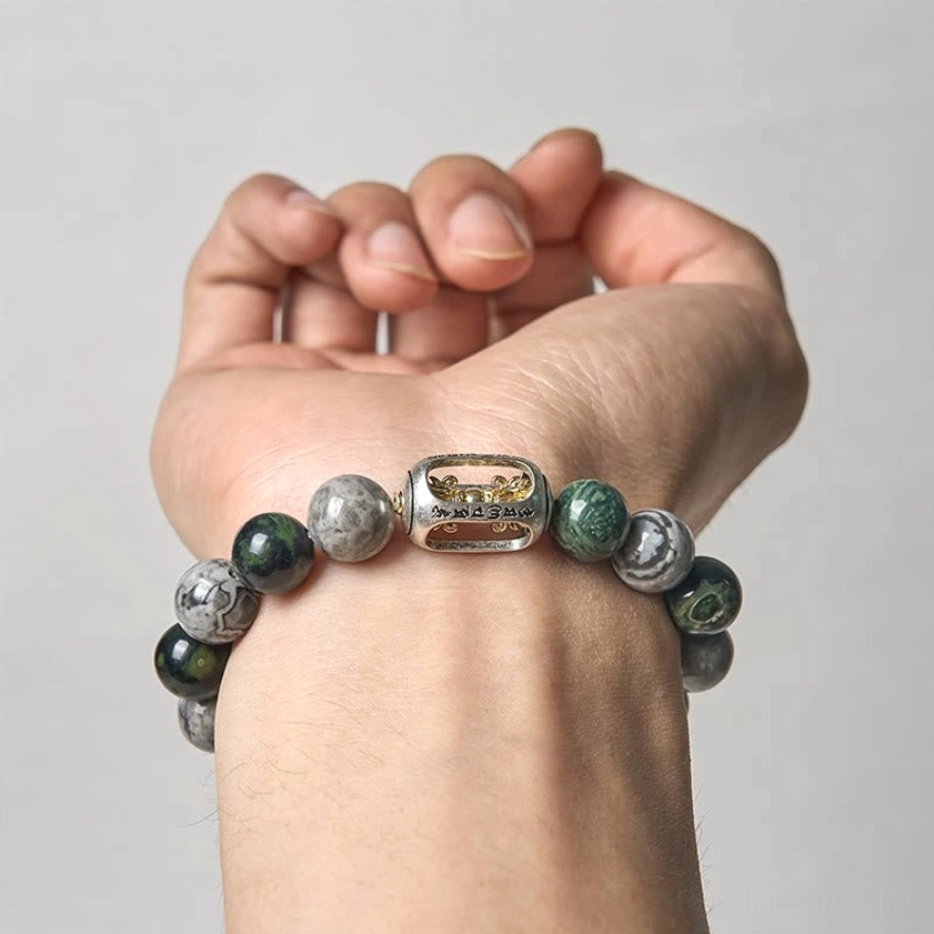 Buddhist healing bracelet fitted on hand displaying engraved Om Mani Padme Hum bead and natural jasper stones