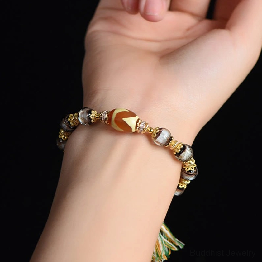 Liuli glass dzi bracelet being worn on wrist, showing natural fit and design clarity with black background