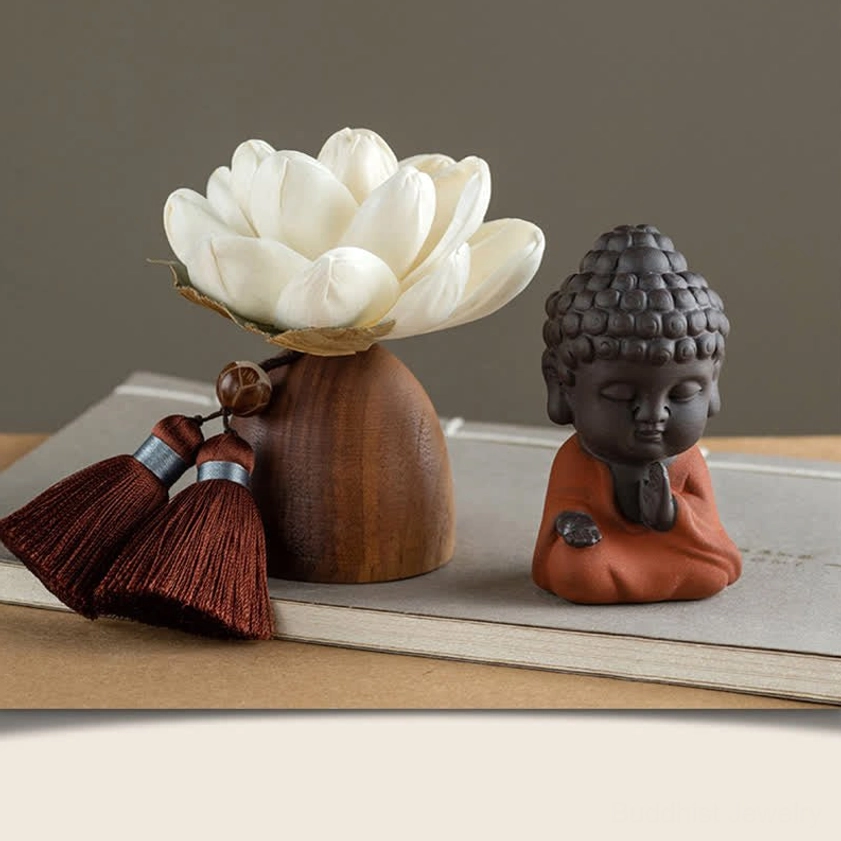 Matte dark ceramic Buddha decoration with wooden lotus stand and red tassels on desk