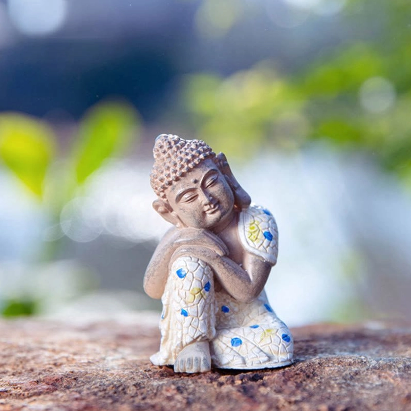 Close-up serene Buddhist Buddha figurine with intricate mosaic robe details, highlighting peaceful meditation expression