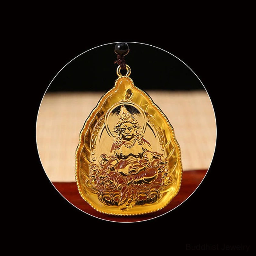 Magnified circular close-up of golden Buddha pendant showing intricate hand-embossed Buddha design with smooth crystal surface and gold border frame