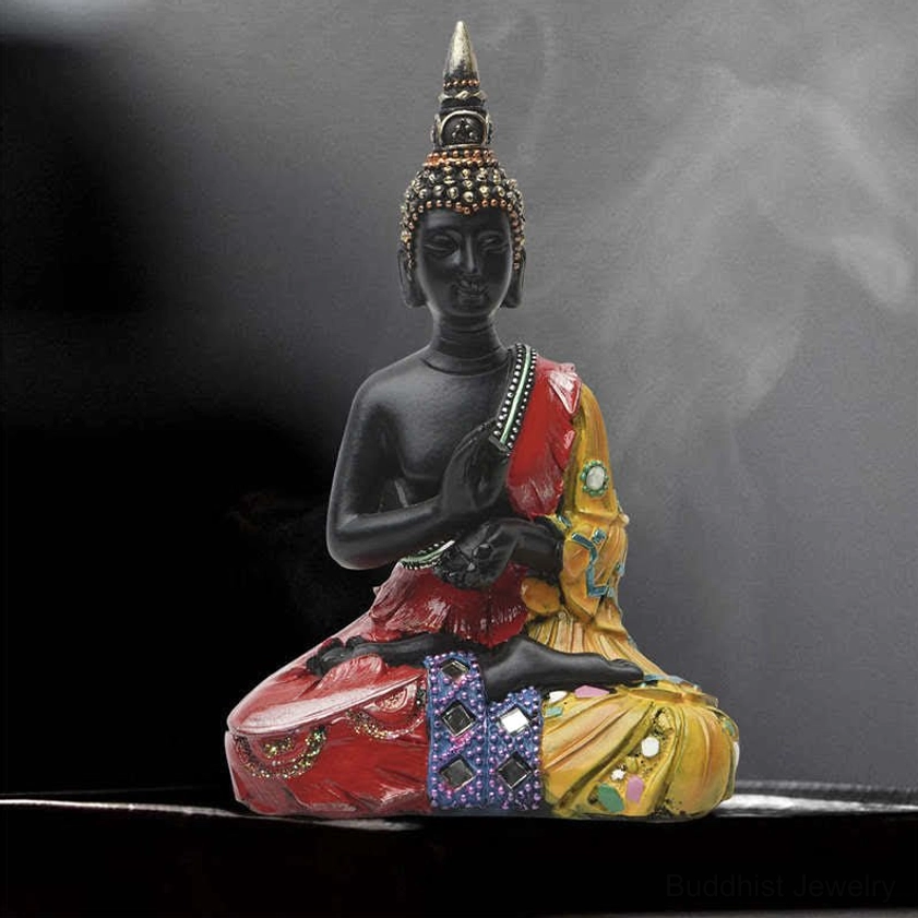Thai Buddha resin statue dark background with incense smoke, displayed on dark tray with ornate robes
