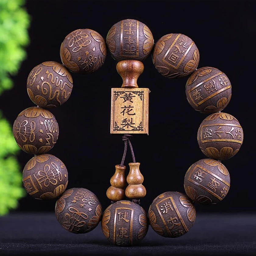 Buddhist prayer bracelet with round carved beads and traditional gourd pendant, studio photography on dark background