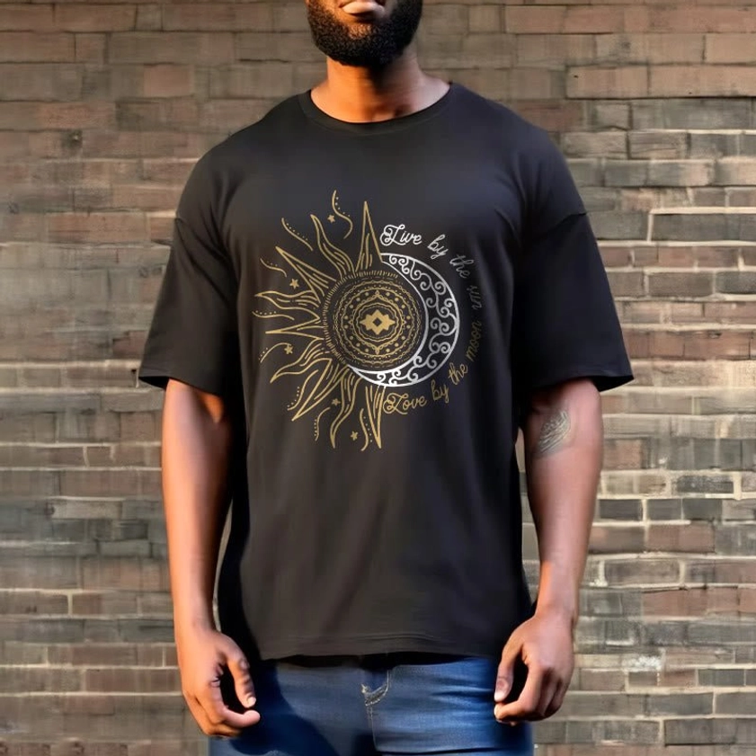Man wearing Live by the Sun Love by the Moon Buddhist tee outdoor brick wall background with detailed celestial print