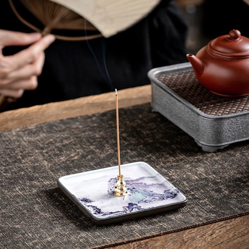 Handcrafted ceramic Buddhist incense burner tray with landscape design displayed on traditional tea table with brass holder