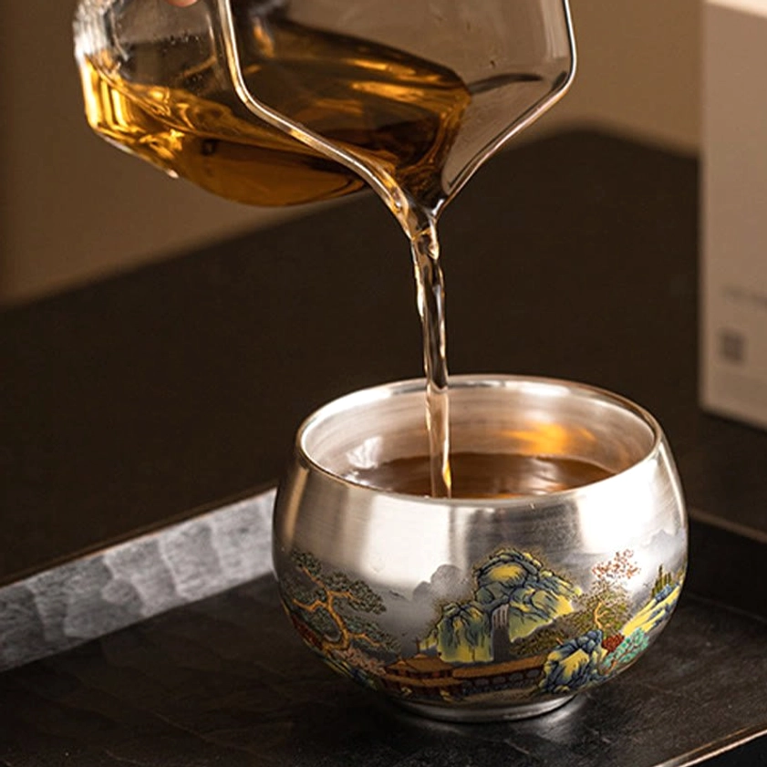 Handcrafted Buddhist ceramic tea cup close-up showing enameled silver finish and artisan quality