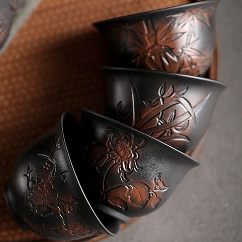 Handcrafted ceramic Buddhist tea cup collection showing multiple design variations and styles