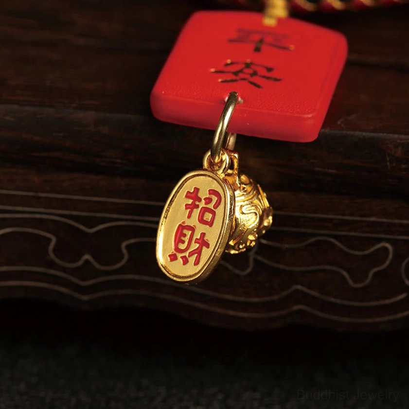 Buddhist prosperity charm hanging trinkets close-up with red Ping An tag and gold Zhao Cai wealth plate