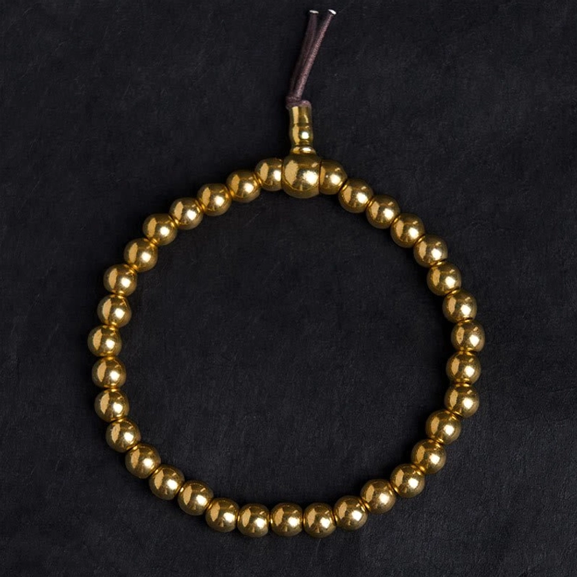 Full copper brass prayer bead bracelet strand showing metal guru bead and leather tassel detail