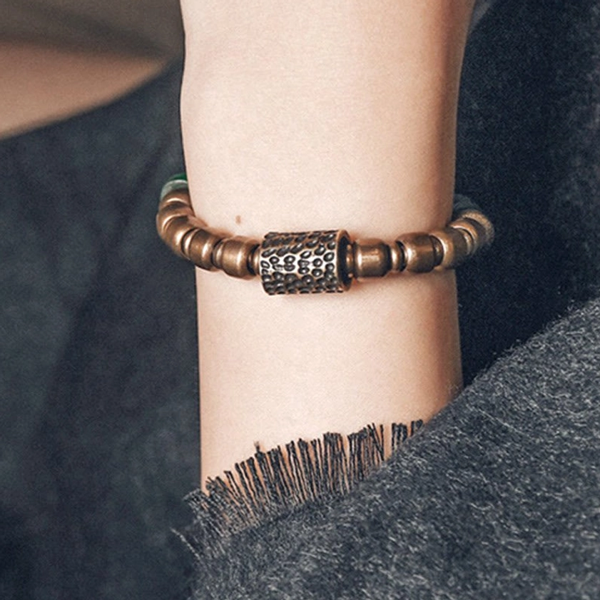 Buddhist-inspired copper bracelet front wrist view showcasing square hammered metal spacer and smooth copper beads