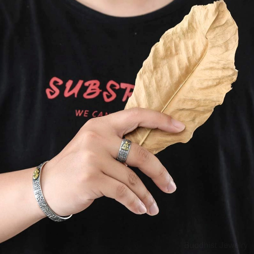 Buddhist adjustable copper ring worn on middle finger showing vintage silver textured band and openable adjustable design with black shirt background